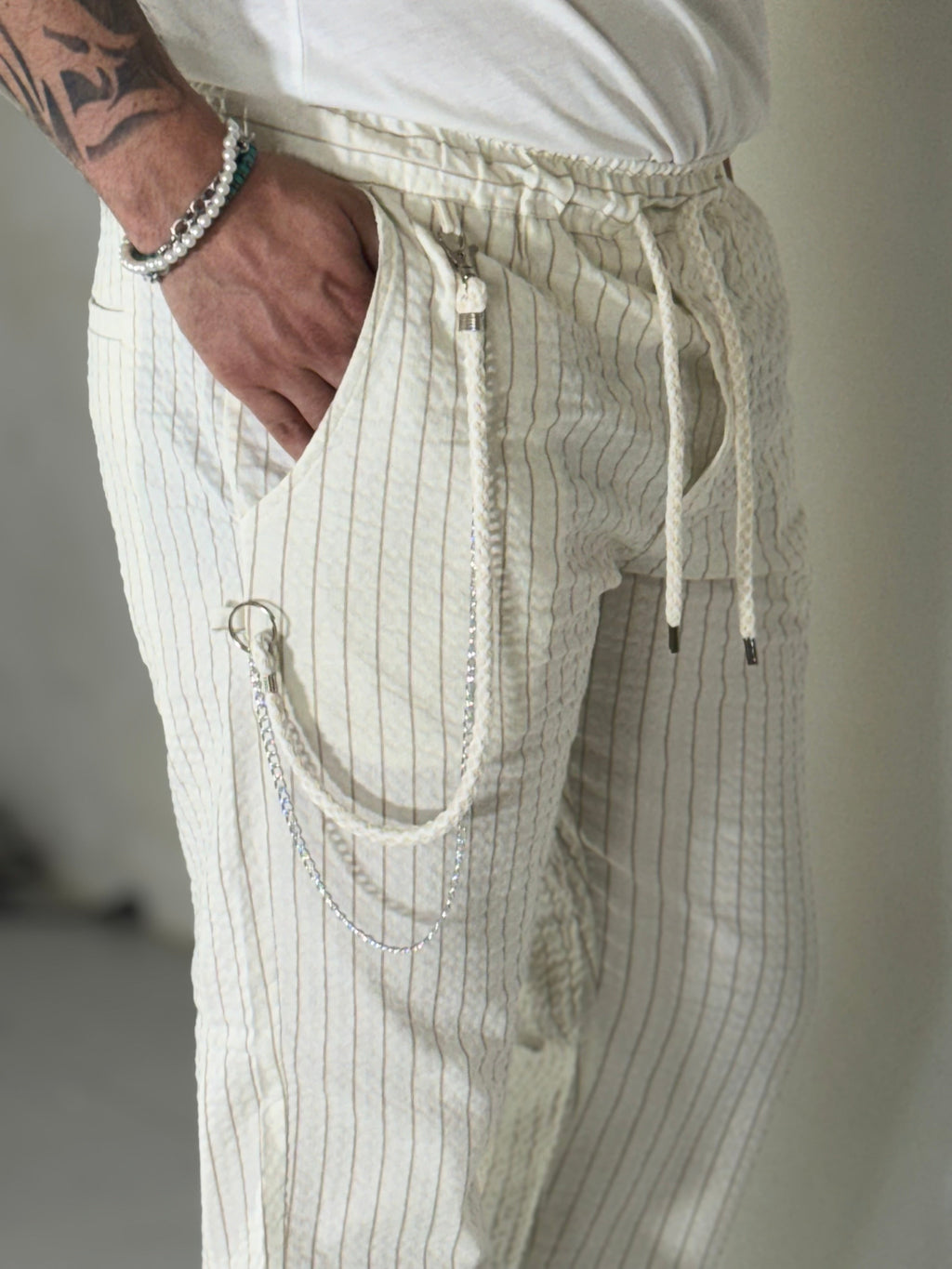 Pantalones a rayas color crema con caída. COREA