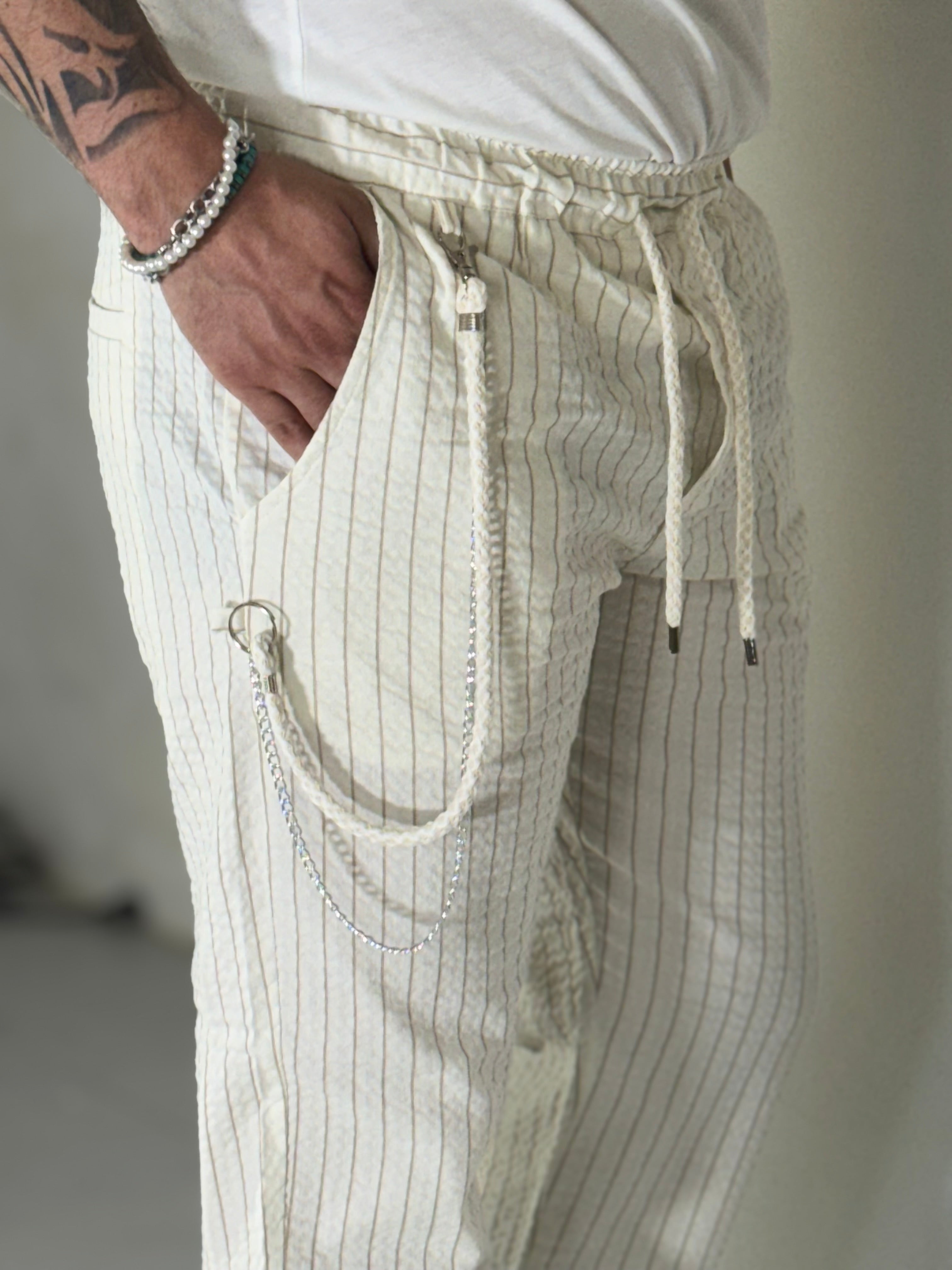 Pantalones a rayas color crema con caída. COREA